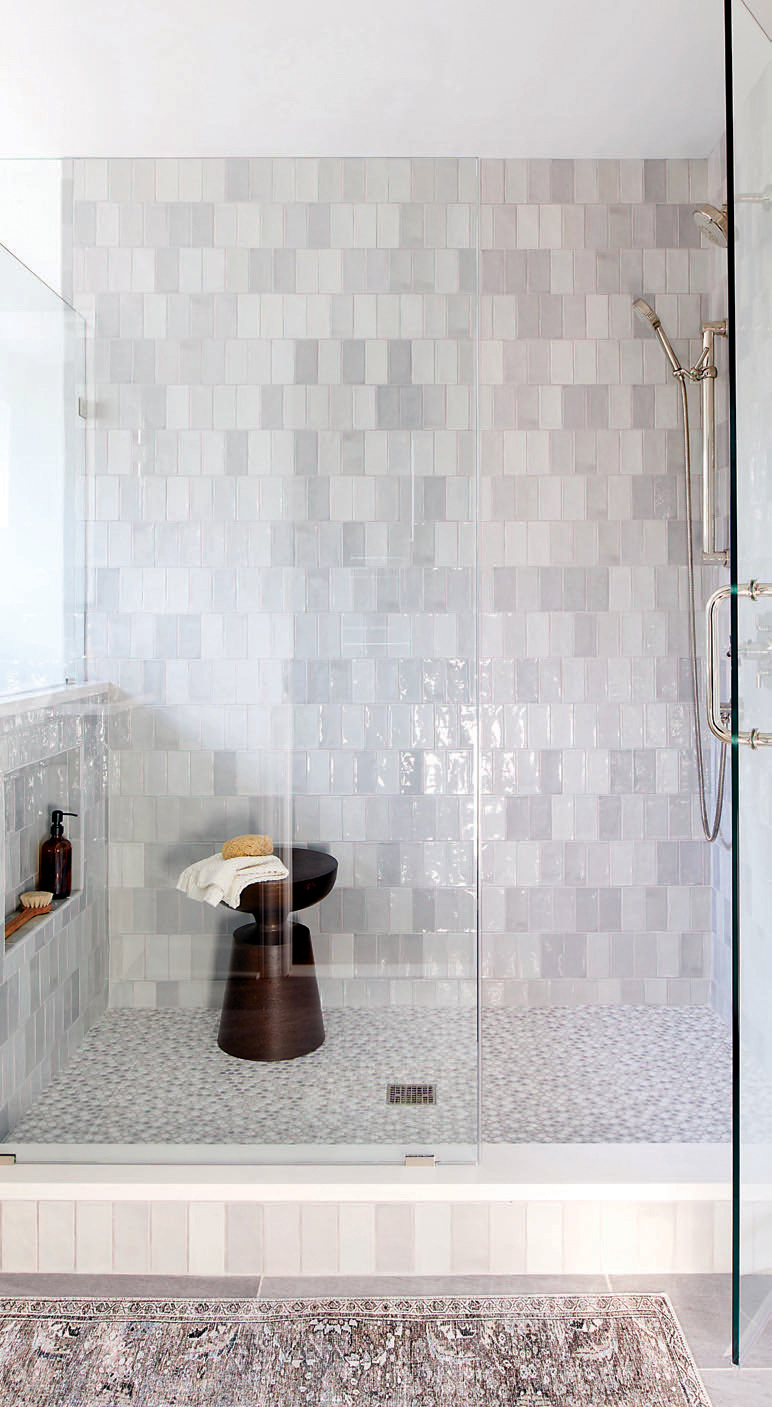 The shower floor of the guest bath features penny round light gray mix gloss porcelain mosaic tile from Tile Lux.